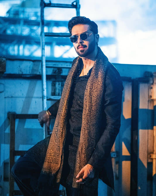 Fahad Mustafa wearing Snug black farshi outfit for men with embroidered shawl premium ethnic wear
